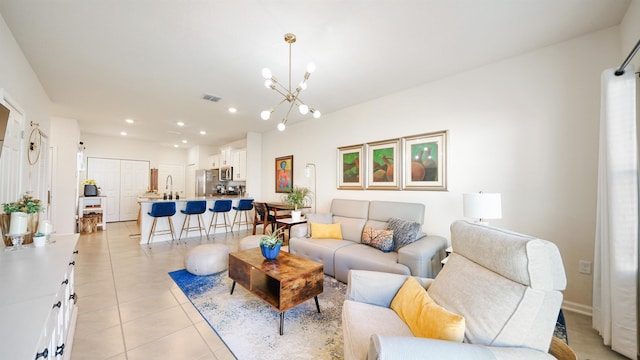 living room featuring light tile patterned floors, a chandelier, and sink