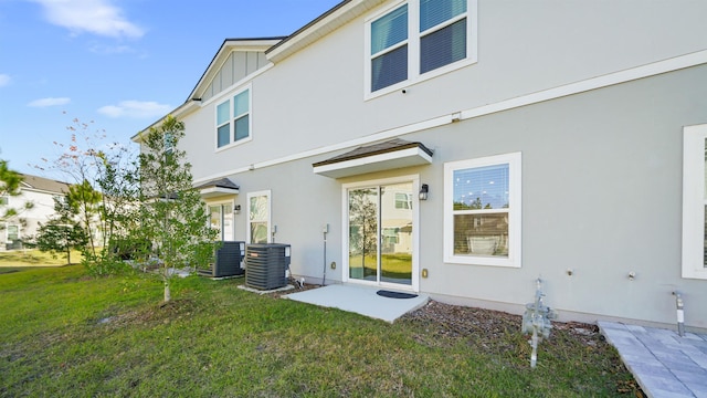 back of property with a lawn, central AC unit, and a patio