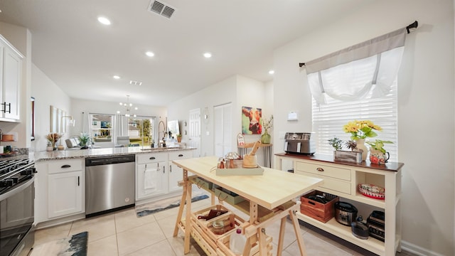 kitchen featuring sink, white cabinets, an inviting chandelier, dishwasher, and light stone countertops