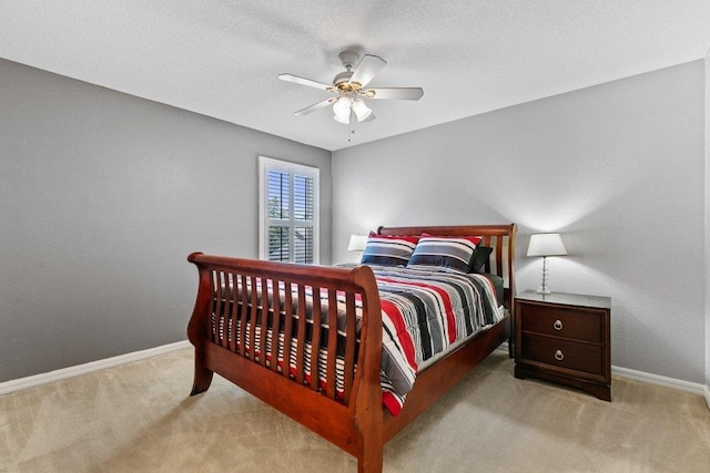 carpeted bedroom with a ceiling fan and baseboards