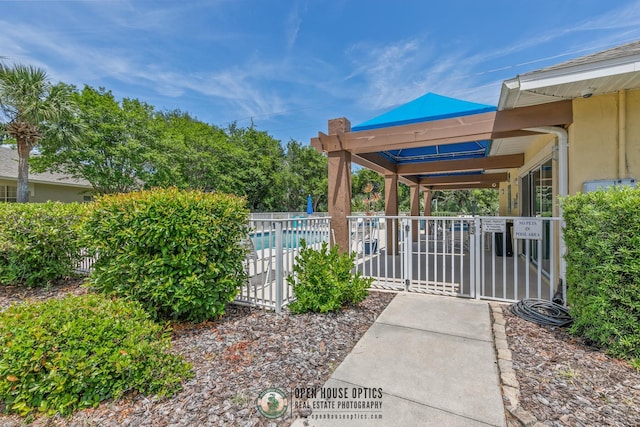 view of gate with a community pool and fence