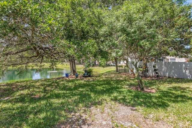view of yard featuring a water view and fence