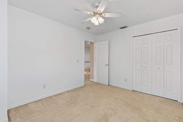 unfurnished bedroom featuring baseboards, carpet flooring, a textured ceiling, and visible vents