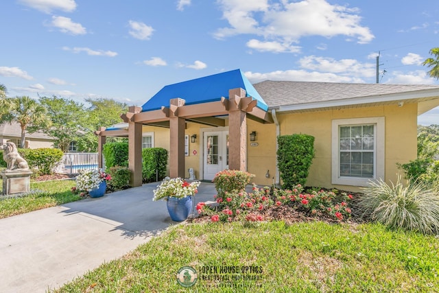 bungalow-style home with roof with shingles, fence, stucco siding, and driveway