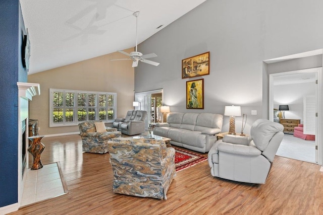 living area featuring a ceiling fan, wood finished floors, a wealth of natural light, and high vaulted ceiling