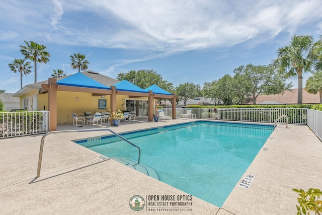 pool featuring fence and a patio area