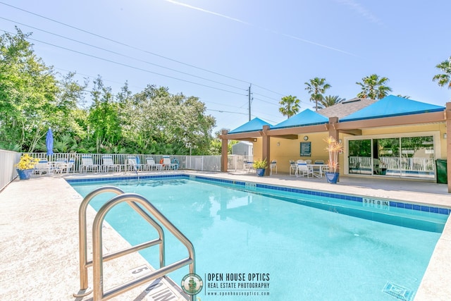 community pool featuring fence and a patio