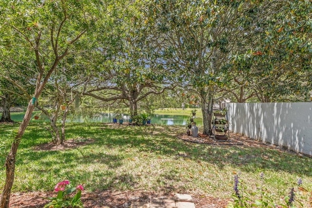 view of yard featuring a water view and fence