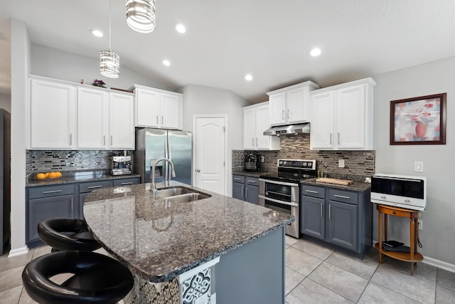 1337 Nochaway Dr, Saint Augustine, FL 32092 - kitchen with a sink, stainless steel appliances, under cabinet range hood, decorative backsplash, and a center island with sink