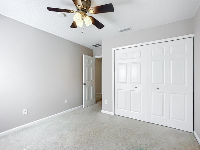 unfurnished bedroom with ceiling fan, light carpet, and a closet