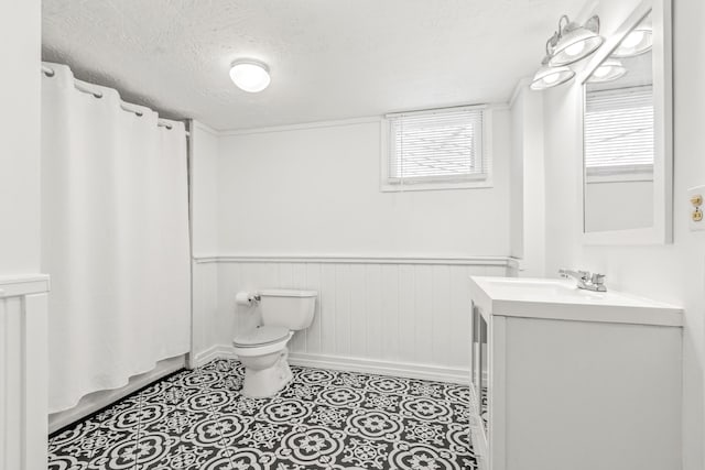 26 Ponce De Leon Ave, Saint Augustine, FL 32080 - bathroom featuring vanity, a textured ceiling, wainscoting, and tile patterned flooring