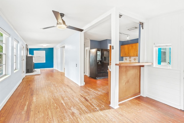 26 Ponce De Leon Ave, Saint Augustine, FL 32080 - kitchen with black refrigerator with ice dispenser, ceiling fan, light wood-type flooring, brown cabinetry, and a peninsula