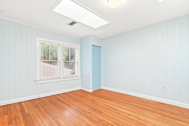 26 Ponce De Leon Ave, Saint Augustine, FL 32080 - unfurnished room featuring light wood-style floors, a skylight, and wood walls