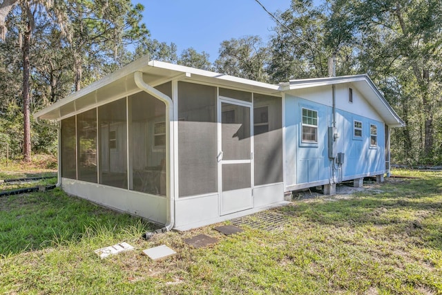 view of home's exterior featuring a yard and a sunroom