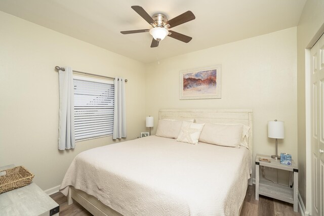 bedroom with dark hardwood / wood-style floors and ceiling fan