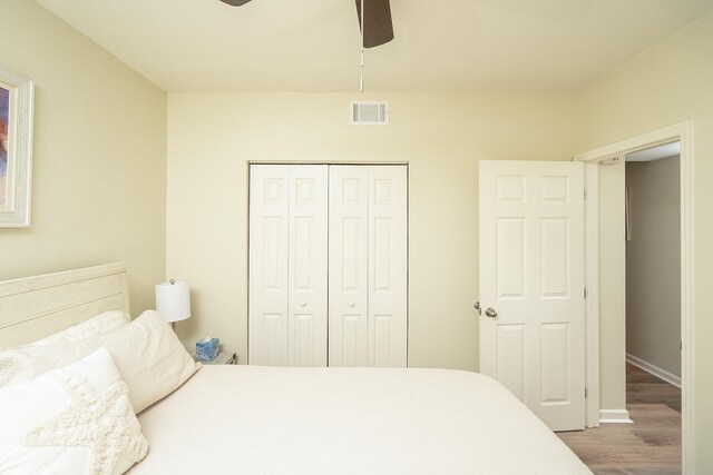 bedroom featuring hardwood / wood-style flooring, ceiling fan, and a closet