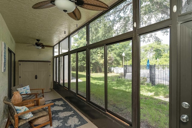 unfurnished sunroom with ceiling fan