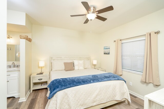 bedroom featuring wood-type flooring, sink, and ceiling fan