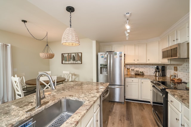 kitchen with rail lighting, sink, white cabinetry, decorative light fixtures, and appliances with stainless steel finishes