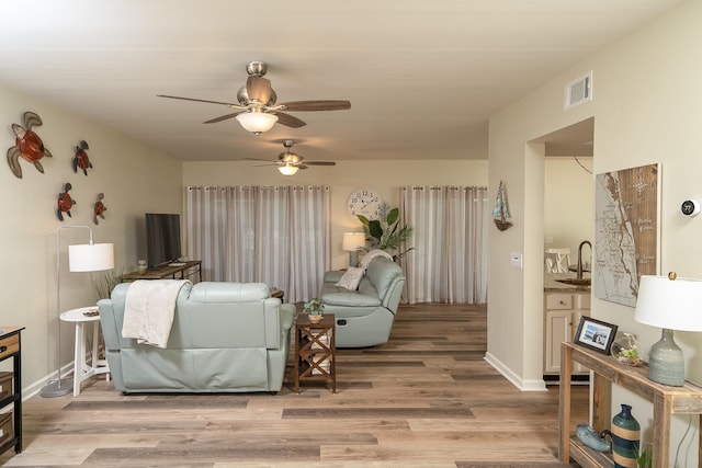 living room featuring sink and light hardwood / wood-style flooring