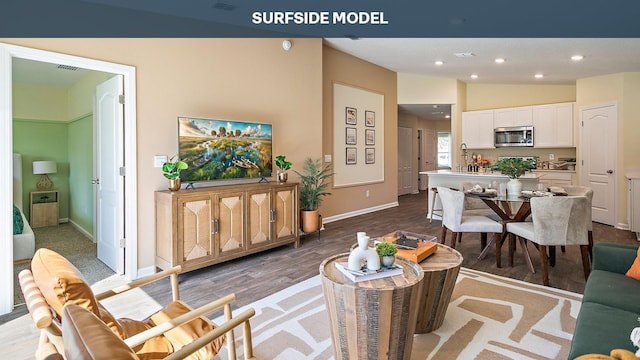 living room with hardwood / wood-style floors, sink, and vaulted ceiling