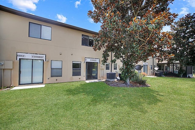 rear view of house with a yard and central AC unit
