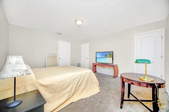 bedroom with carpet floors and a textured ceiling