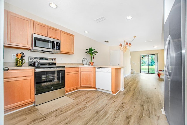 kitchen featuring kitchen peninsula, appliances with stainless steel finishes, light brown cabinets, an inviting chandelier, and light hardwood / wood-style flooring