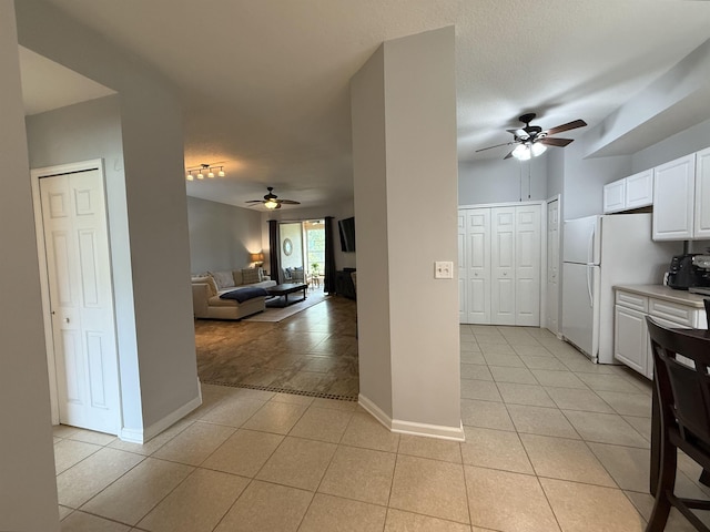1804 Prestwick Pl Unit 1804, Saint Augustine, FL 32086 - kitchen with light tile patterned floors, ceiling fan, freestanding refrigerator, and white cabinets