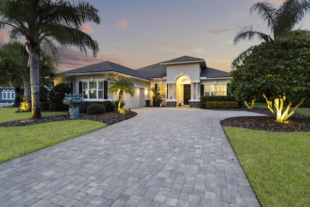 view of front of house featuring a garage and a yard