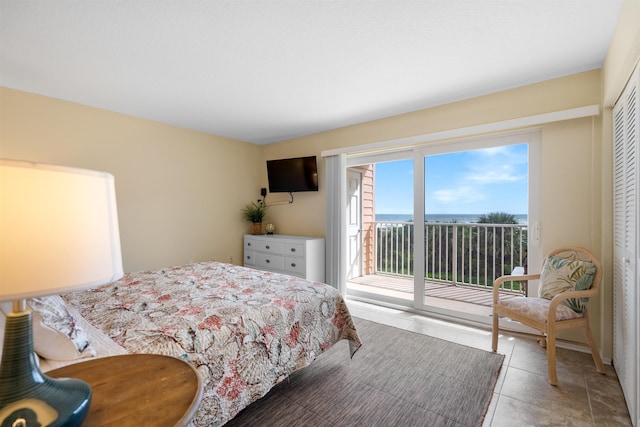 bedroom featuring light tile patterned flooring, access to exterior, and a closet