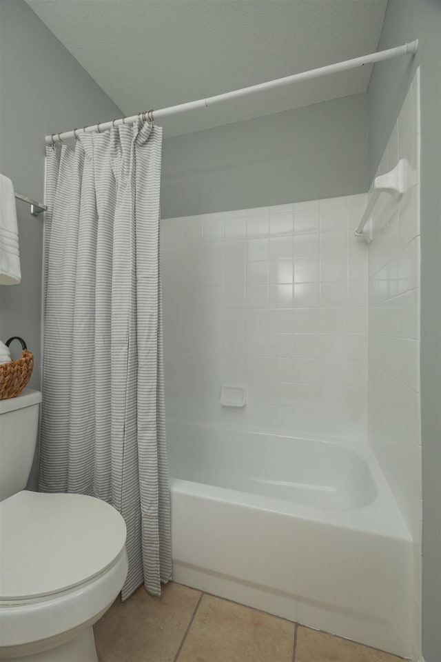 bathroom featuring toilet, tile patterned flooring, and shower / bath combo with shower curtain