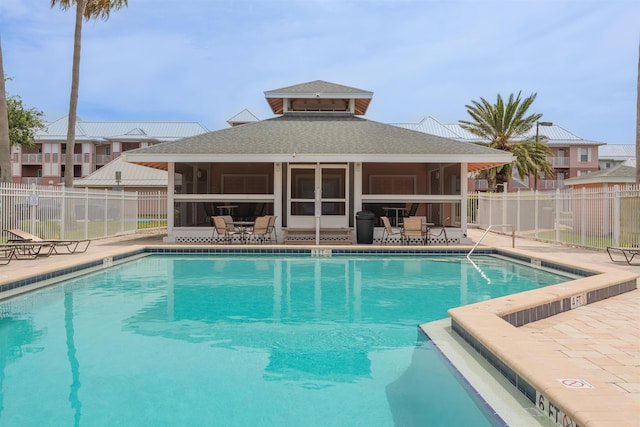 view of swimming pool featuring a patio and a sunroom