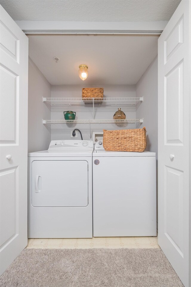 clothes washing area with separate washer and dryer