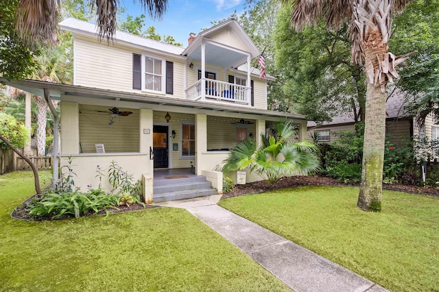 view of front of house with ceiling fan, a porch, a balcony, and a front yard