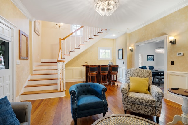 living room with ornamental molding, light hardwood / wood-style floors, and a notable chandelier