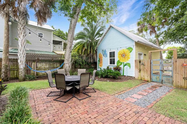 15 Rohde Ave, Saint Augustine, FL 32084 - fenced backyard featuring a gate, a patio, and outdoor dining space