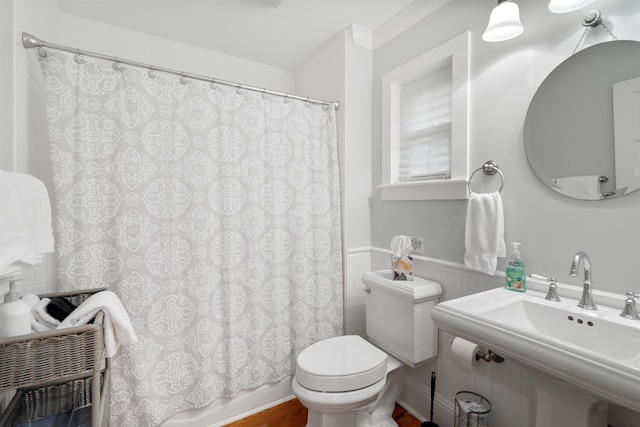 bathroom with crown molding, wood-type flooring, shower / bath combination with curtain, and toilet