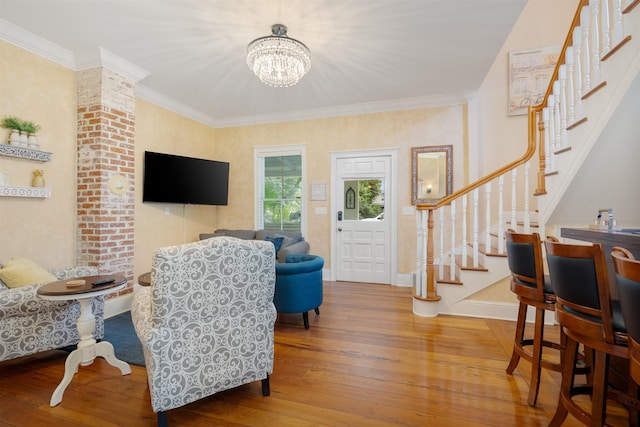 living room featuring hardwood / wood-style floors, a chandelier, and ornamental molding