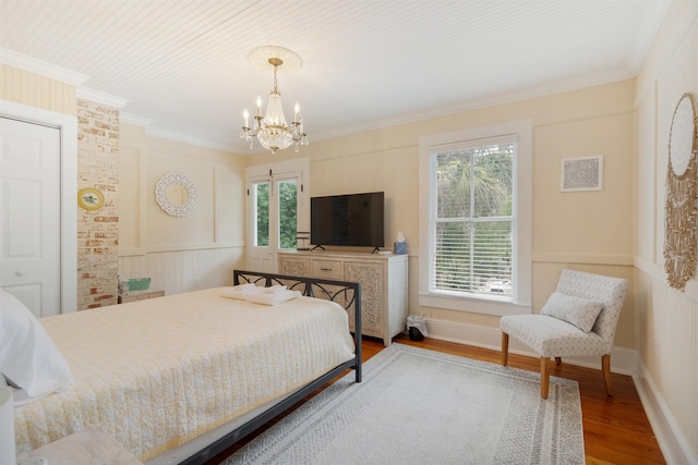 bedroom featuring hardwood / wood-style floors, crown molding, and a chandelier