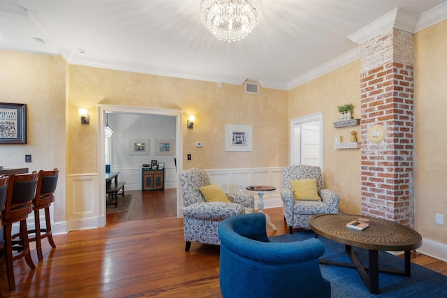 sitting room featuring a chandelier, dark hardwood / wood-style floors, and ornamental molding