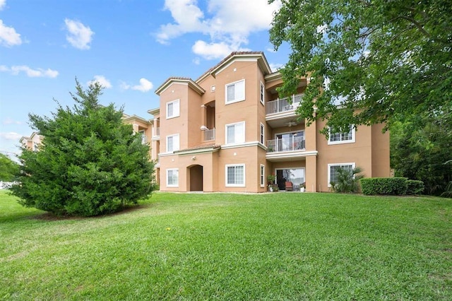 520 Florida Club Blvd Unit 101, Saint Augustine, FL 32084 - rear view of house with a tiled roof, stucco siding, and a lawn