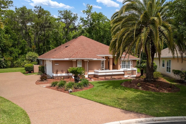 1300 Paradise Pond Rd, Saint Augustine, FL 32092 - view of front facade featuring concrete driveway, stucco siding, a front lawn, and roof with shingles
