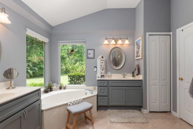 1300 Paradise Pond Rd, Saint Augustine, FL 32092 - bathroom with lofted ceiling, two vanities, a bath, tile patterned flooring, and a closet