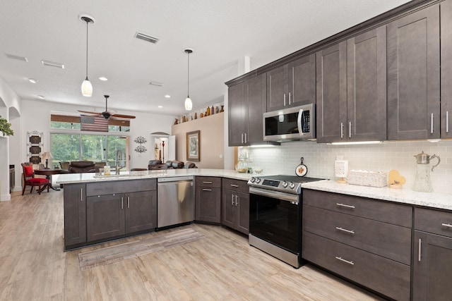 1300 Paradise Pond Rd, Saint Augustine, FL 32092 - kitchen featuring appliances with stainless steel finishes, a peninsula, open floor plan, light wood finished floors, and dark brown cabinets