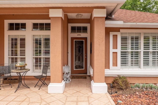 1300 Paradise Pond Rd, Saint Augustine, FL 32092 - view of exterior entry with stucco siding and a shingled roof