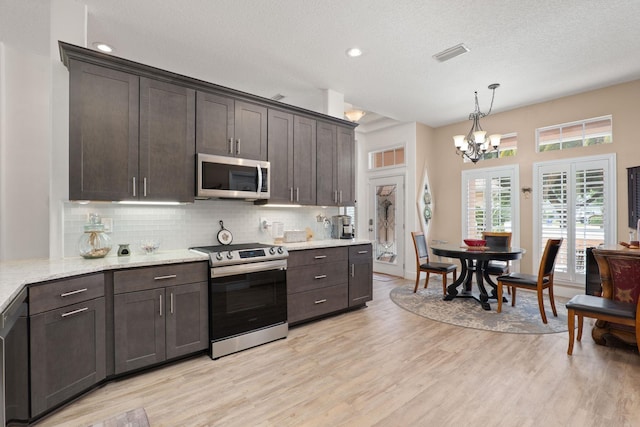 1300 Paradise Pond Rd, Saint Augustine, FL 32092 - kitchen with stainless steel appliances, dark brown cabinets, a chandelier, backsplash, and recessed lighting