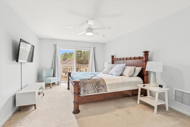 bedroom featuring ceiling fan, access to exterior, light carpet, and a textured ceiling