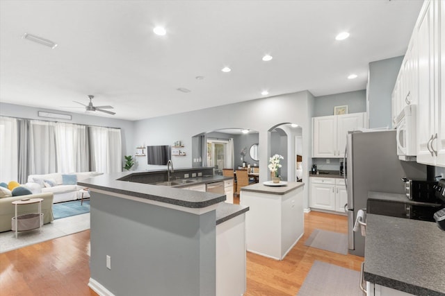 kitchen with a center island, stainless steel dishwasher, white cabinets, light wood-type flooring, and sink