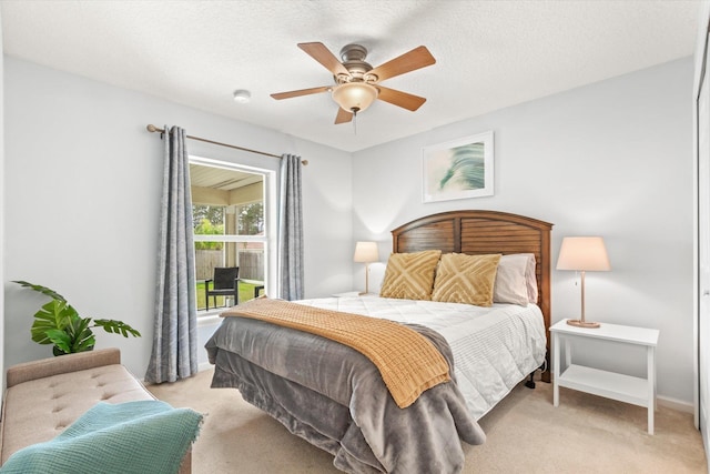 bedroom with ceiling fan, a textured ceiling, and light carpet